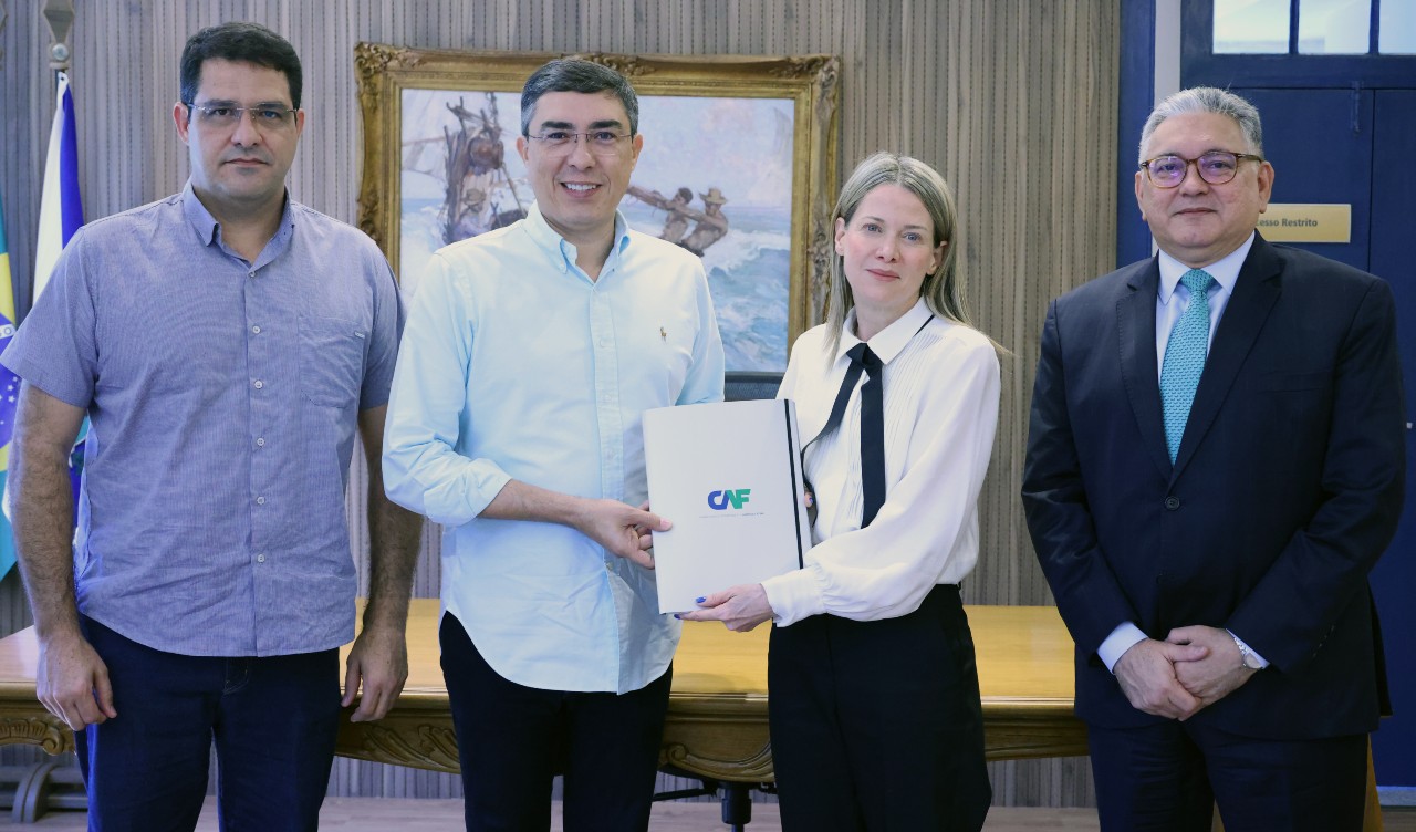 grupo de pessoas posa para a foto mostrando o documento